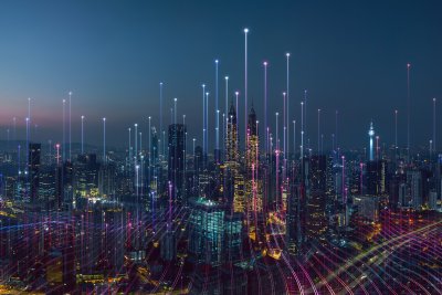 Smart City bei Nacht Die Abbildung zeigt eine digitale Illustration einer futuristischen Smart City bei Nacht mit leuchtenden Datenlinien und der Skyline von Kuala Lumpur (erkennbar an den Petronas Towers).