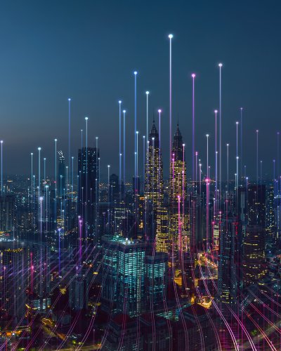 Smart City bei Nacht Die Abbildung zeigt eine digitale Illustration einer futuristischen Smart City bei Nacht mit leuchtenden Datenlinien und der Skyline von Kuala Lumpur (erkennbar an den Petronas Towers).